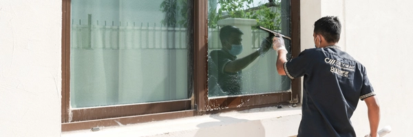 A young man cleaning widnow glass of villa
